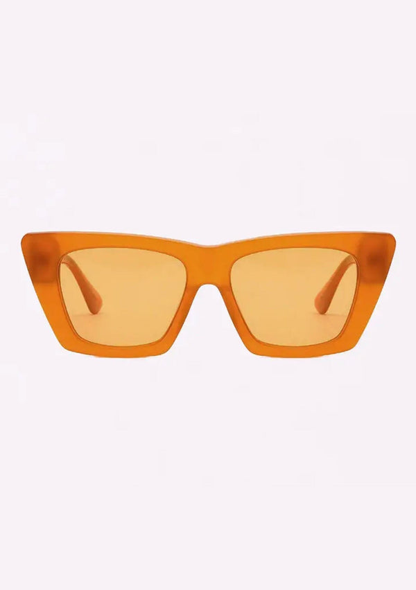 [Color: Apricot] A pair of oversized clear orange plant-based acetate frames with amber lenses, from INDY. 