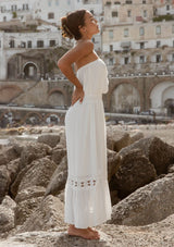 [Color: Off White] A brunette model wearing a white ultra bohemian maxi dress for vacation. This summer maxi dress features a halter neckline and a comfortable smocked waist. This dress is also embellished with intricate lace details and embroidered eyelet. The perfect style for brunch or a tropical vacation.