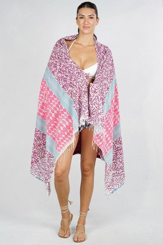 [Color: Mauve] A cotton beach towel showcasing a purple and pink botanical and geometric patchwork print, complete with a double-sided design and fringe accents.