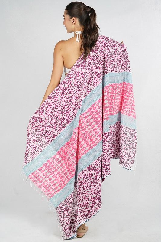 [Color: Mauve] A cotton beach towel showcasing a purple and pink botanical and geometric patchwork print, complete with a double-sided design and fringe accents.