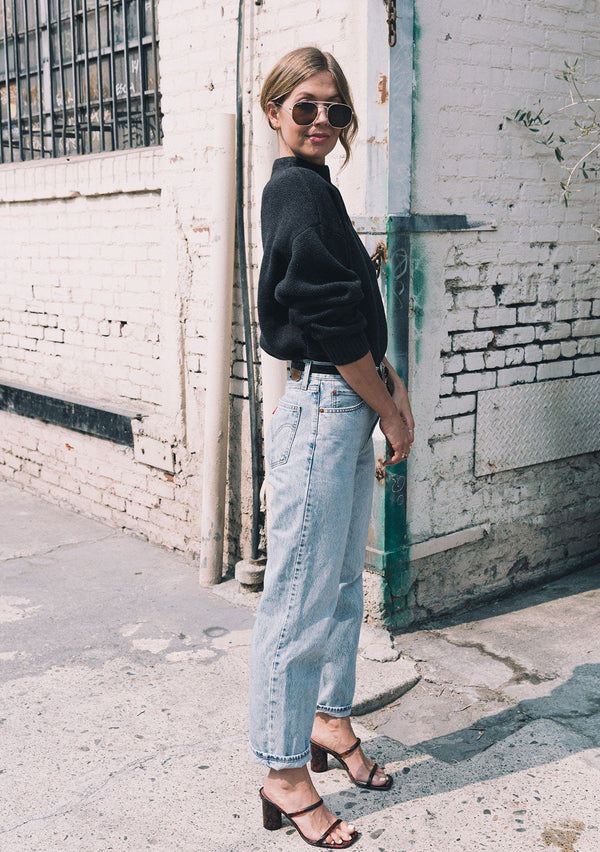 [Color: Charcoal] Charcoal sweater with an elegant funnel neck, a concealed zip closure at the back neck, and contrast ribbed details. Styled with vintage jeans and strappy sandals.