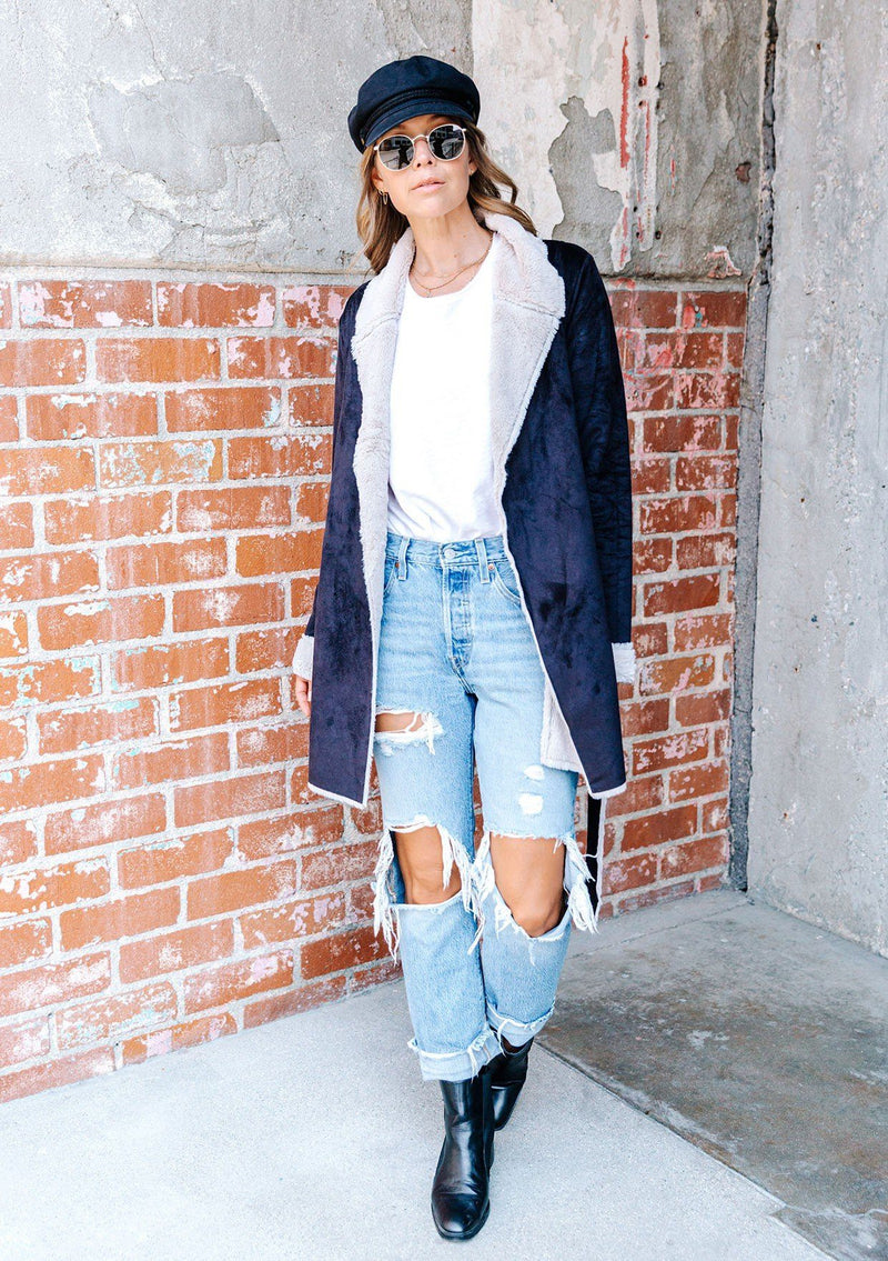 [Color: Black Oat] A faux shearling coat in vegan suede. Featuring a cozy faux shearling interior and trim, a waist defining self tie belt, and essential side pockets. This timeless style is worn here with denim for a chic Fall look.