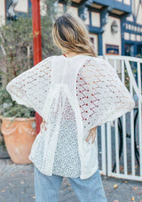 [Color: Off White] Girl wearing a white crochet short sleeve cocoon cardigan.