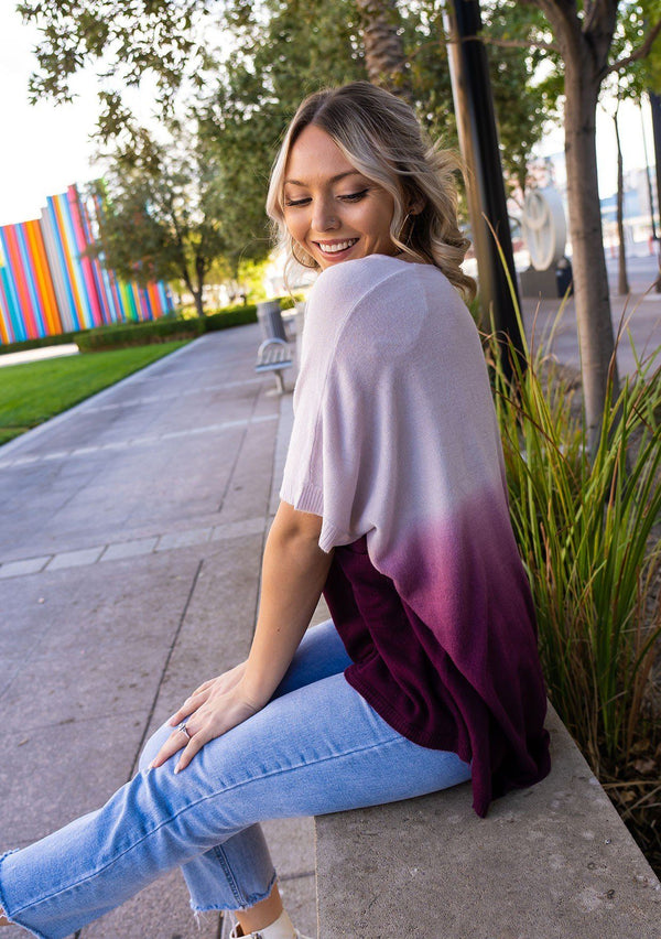 [Color: Lavender] A blond woman wearing an Ombre tie dye sweater top. Features a scooped neckline, breezy side vents and front pockets. 