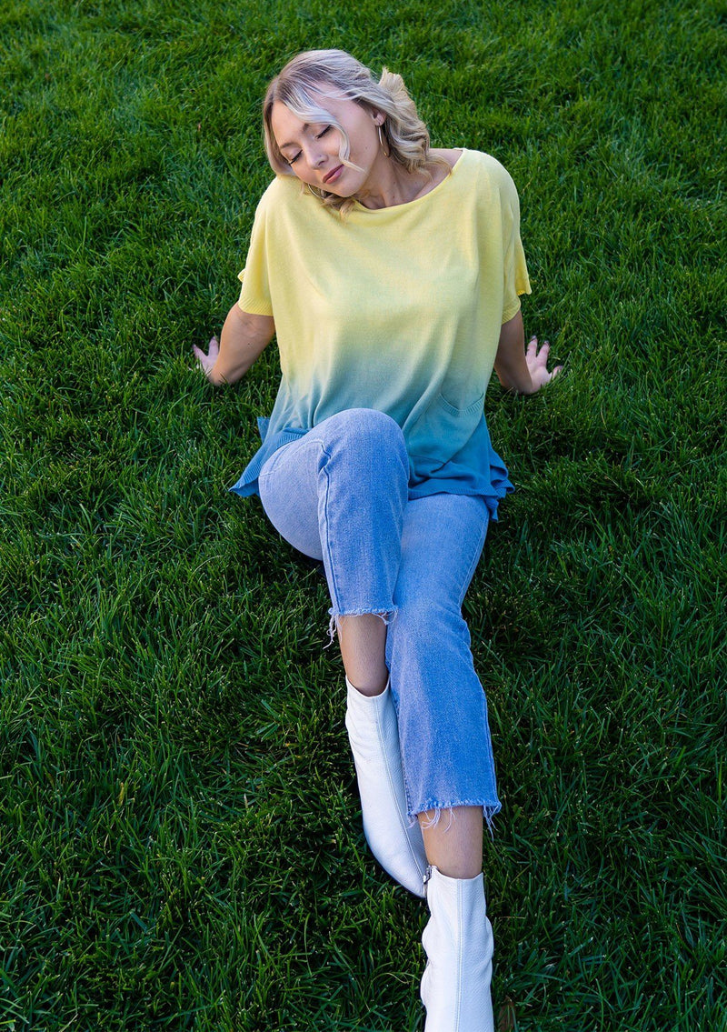 [Color: Lemon] A blond woman wearing an ombre tie dye sweater top. Features a scooped neckline, breezy side vents and front pockets. 