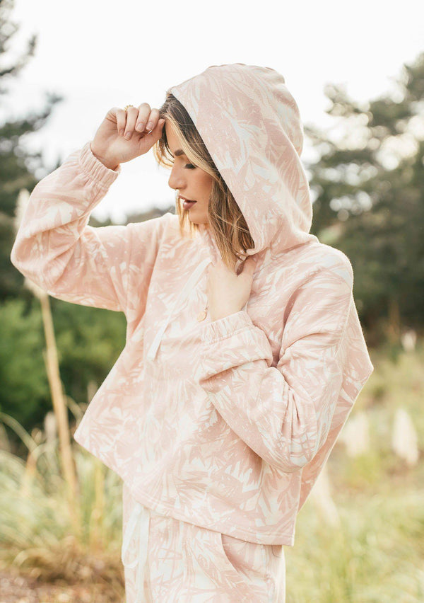 [Color: Blush/Natural] Girl wearing a pink tropical print lounge hoodie.