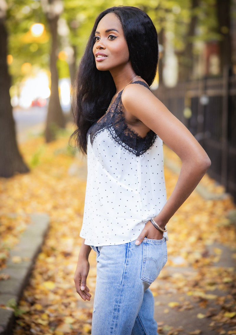 [Color: White Black] A lace trim camisole in an allover polka dot print. Featuring a delicate lace trim v neckline in front and a v neckline in back, lace straps, and a relaxed draped silhouette. 