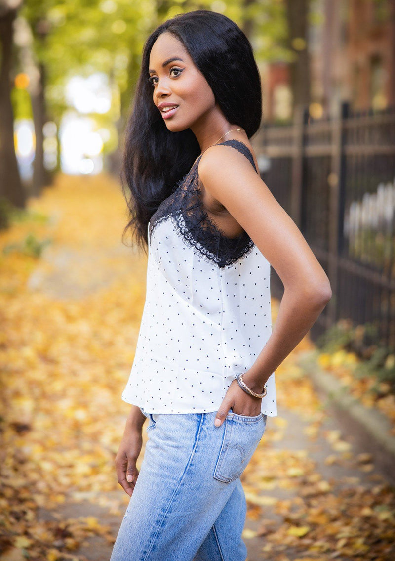 [Color: White Black] A lace trim camisole in an allover polka dot print. Featuring a delicate lace trim v neckline in front and a v neckline in back, lace straps, and a relaxed draped silhouette. 