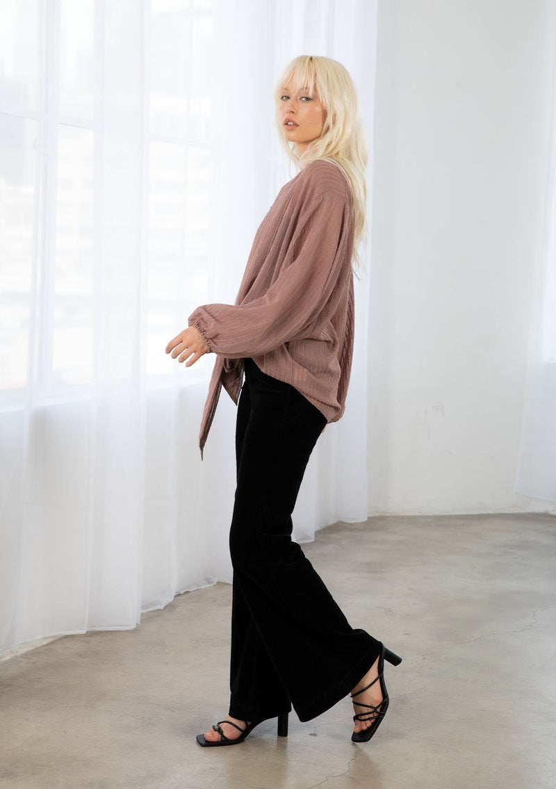 [Color: Dusty Rose] A model wearing a soft sheer dusty rose kimono top in a tonal shadow stripe. With long voluminous sleeves, elastic wrist cuffs, and a wrap tie front that can be tied in multiple ways. 