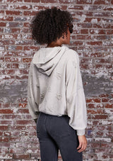 [Color: Stone] A soft lounge hooded sweatshirt featuring subtle distressed details, flattering dolman sleeves, and a slouchy hoodie. Styled here with jeans.