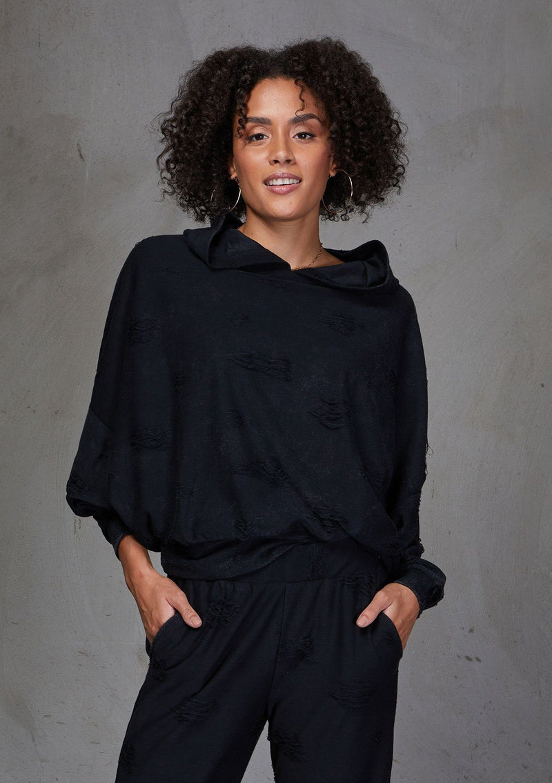 [Color: Black] A soft lounge hooded sweatshirt featuring subtle distressed details, flattering dolman sleeves, and a slouchy hoodie. Styled here with jeans.