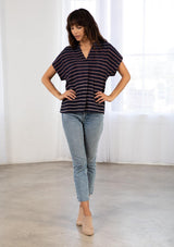 [Color: Navy/Blue] A model wearing a classic navy blue popover top in a gradient stripe print. Featuring a banded collar, short dolman sleeves with a folded cuff, and a sophisticated front pleat.