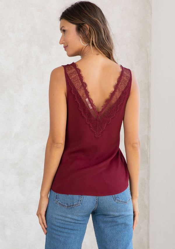 [Color: Merlot] A model wearing a merlot red camisole tank top. With a lace trim v neckline in front and back and a relaxed fit. 