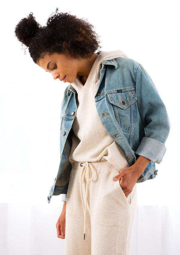 [Color: Seashell] A model wearing a seashell beige cropped hoodie. With a raw edge hemline and a long sleeve with dropped shoulder.