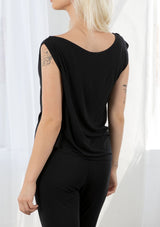 [Color: Black] A model wearing a classic black athleisure tank top. With a boat neckline, a gathered detail along the left shoulder, and a boxy fit.