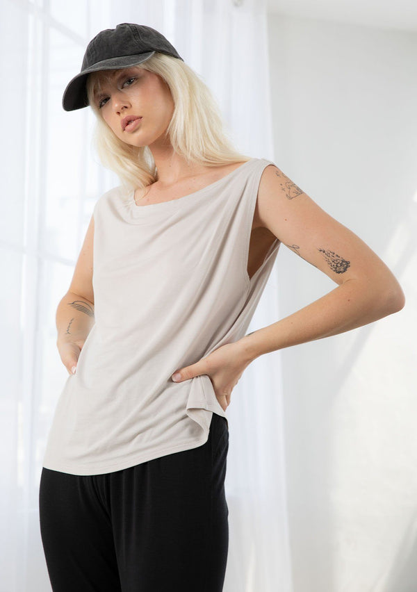 [Color: Mushroom] A model wearing a classic grey athleisure tank top. With a boat neckline, a gathered detail along the left shoulder, and a boxy fit.