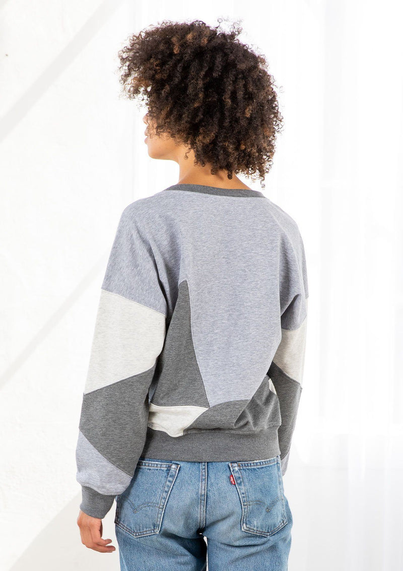 [Color: Heather Grey Combo] A model wearing a classic French terry sweatshirt in a trendy patchwork panel design. With a crew neckline and a contrast ribbed trim. 