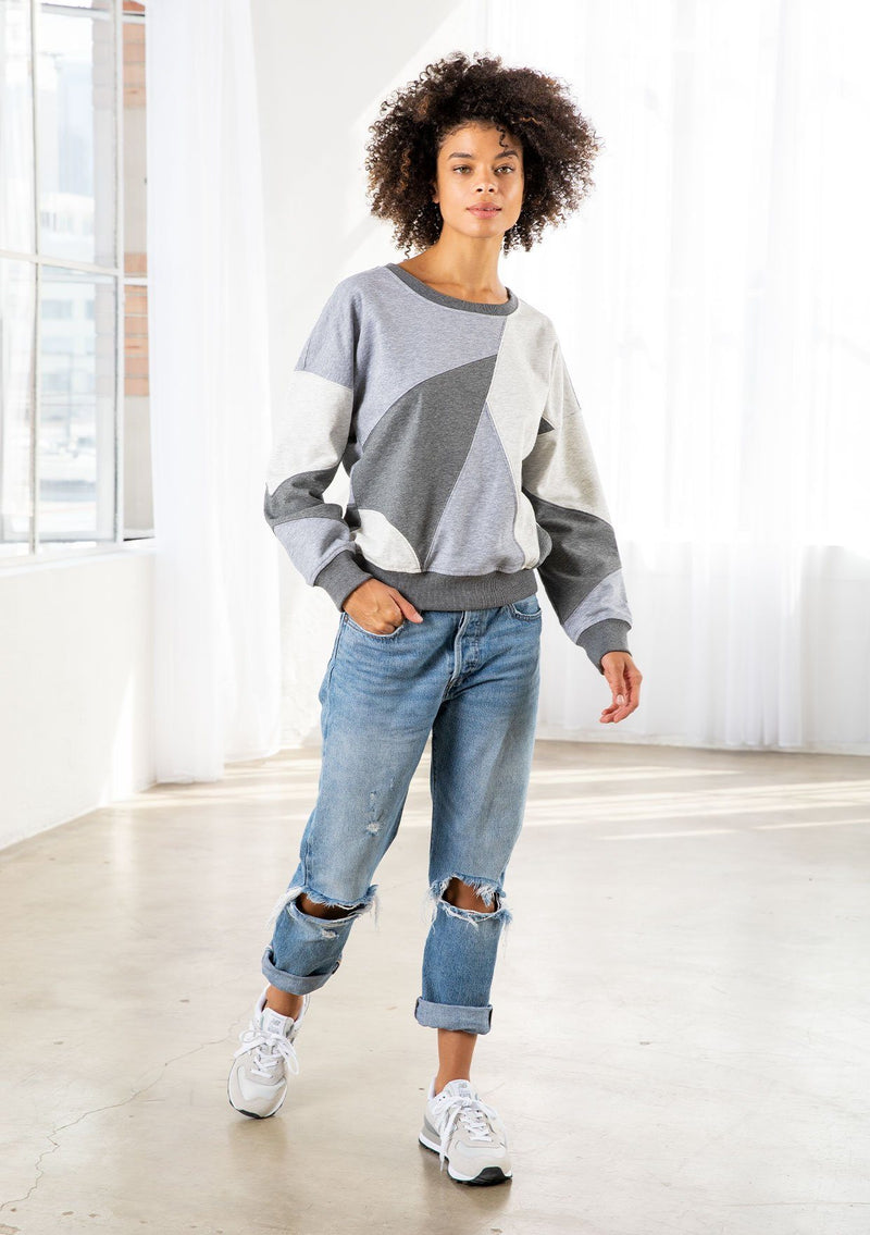 [Color: Heather Grey Combo] A model wearing a classic French terry sweatshirt in a trendy patchwork panel design. With a crew neckline and a contrast ribbed trim. 