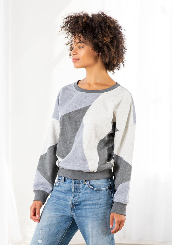 [Color: Heather Grey Combo] A model wearing a classic French terry sweatshirt in a trendy patchwork panel design. With a crew neckline and a contrast ribbed trim. 