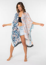 [Color: Lt Blue/Sand] A model wearing a stunning mid length kimono in a light blue mixed floral print. Featuring half length kimono sleeves, side slits, and an open front.