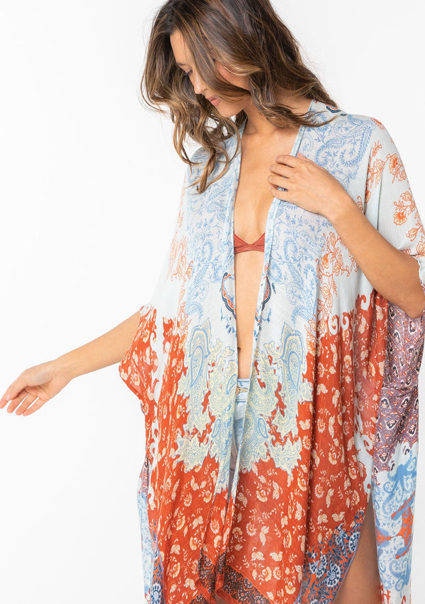 [Color: Light Blue/Red] A model wearing an abstract blue and red floral print mid length kimono. With half length kimono sleeves, an open front, and side slits.