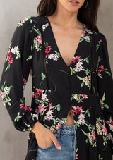 [Color: Black/Red] A model wearing a dreamy black bohemian maxi kimono with a pink floral print. With long sleeves, high slits, and a self covered button front top. 