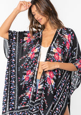 [Color: Royal Blue/Black] A model wearing a blue, black and pink floral border print kimono. 