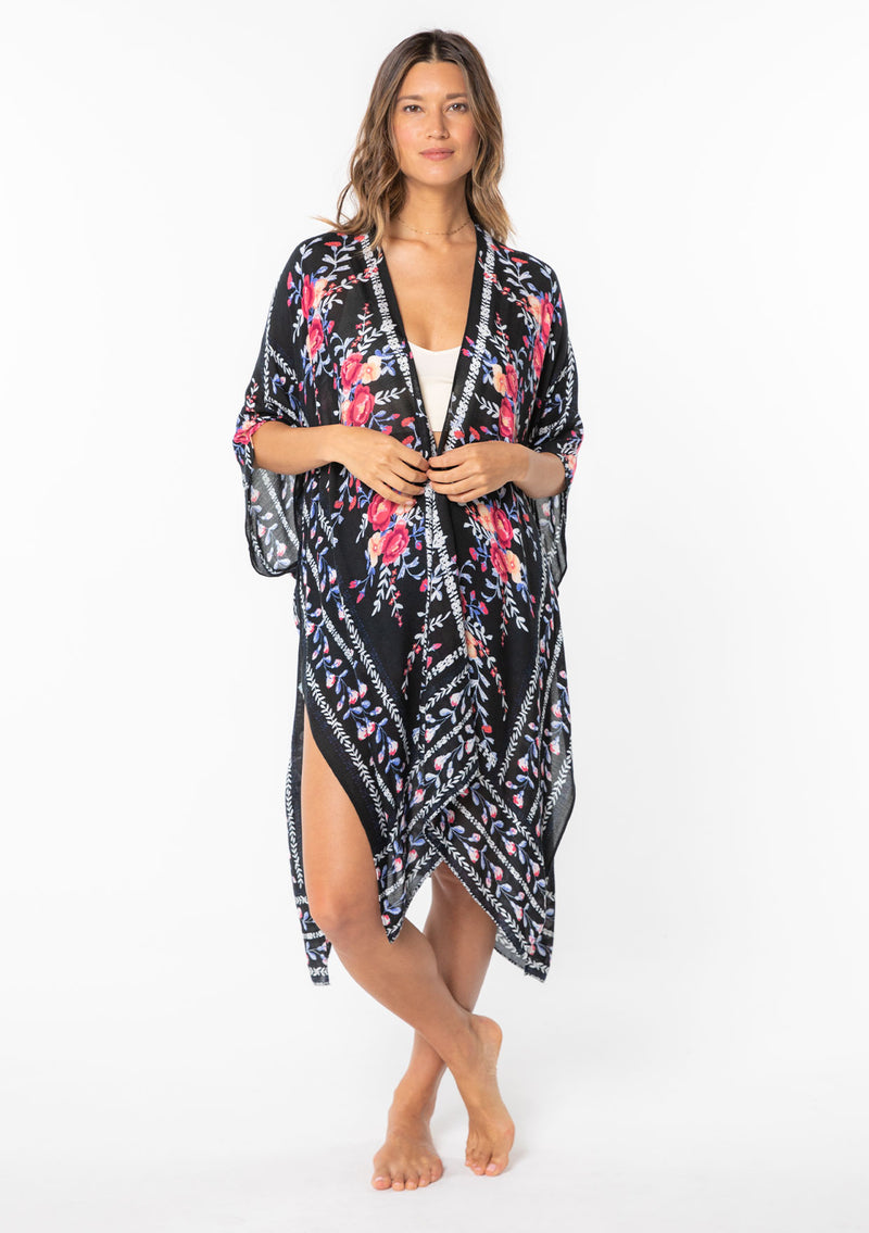 [Color: Royal Blue/Black] A model wearing a blue, black and pink floral border print kimono. 