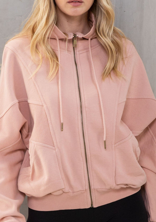 [Color: Pink] A model wearing a lounge worthy, vintage inspired funnel neck zip up sweatshirt. With a drawstring funnel neck, side pockets, and paneled details. 