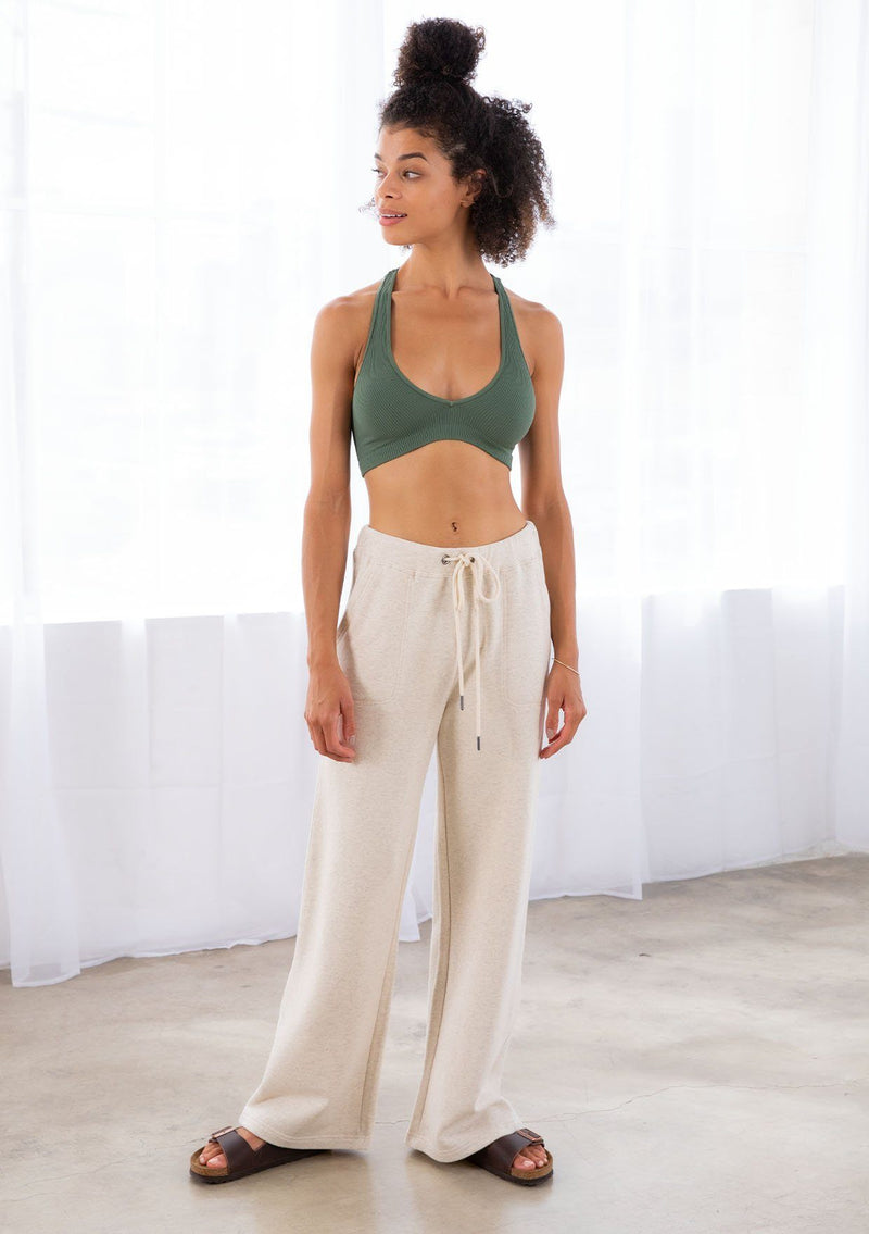 [Color: Seashell] A model wearing a seashell beige pull on style wide leg jogger pant made with soft French terry. With a drawstring waist and essential side pockets.