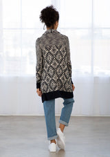 [Color: Navy/Nude] A woman wearing a navy and nude bohemian diamond pattern mid length cardigan. With a shawl collar, an open front, and contrast ribbed trim. 