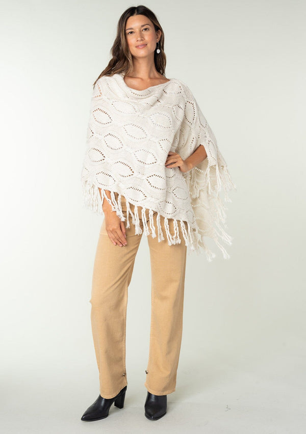 [Color: Heather Cream] A vintage inspired sweater poncho knit from a cream speckled yarn. With a fringed hemline. 