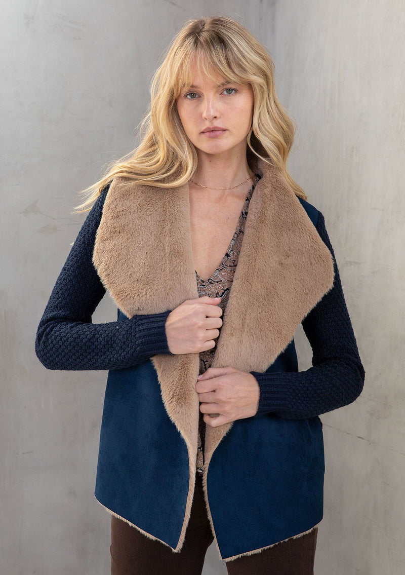 [Color: Navy/Camel] A model wearing a cozy knit and faux suede cardigan in classic camel and navy. With an oversize collar and faux shearling trim. 