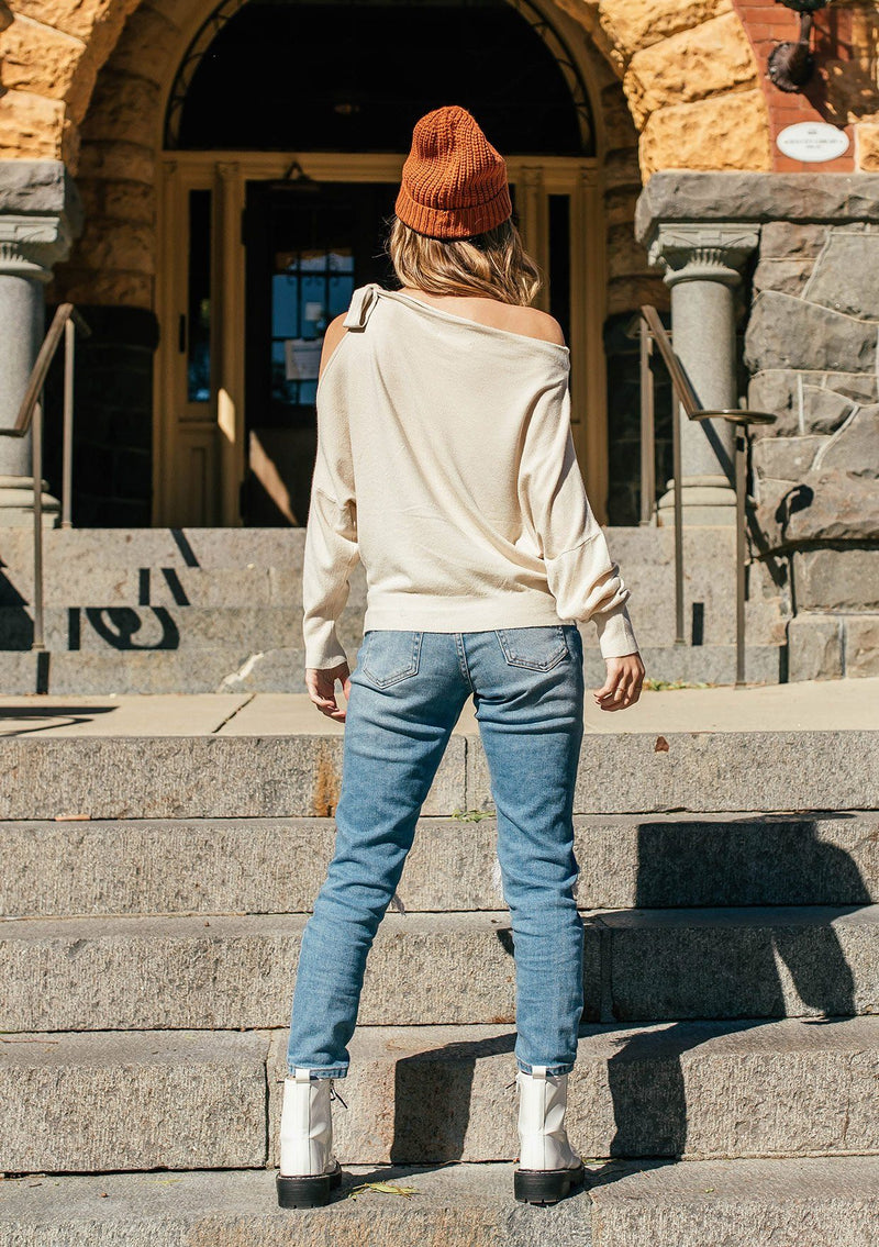 [Color: Vanilla] A girl wearing a white oversized cozy pullover sweater.