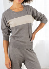 [Color: Heather Smoke/Stone] A model wearing a soft and lightweight grey pullover sweater. With long sleeves, a dropped shoulder, a round neckline, contrast ribbed trim, and a wide stripe detail across the front chest. 