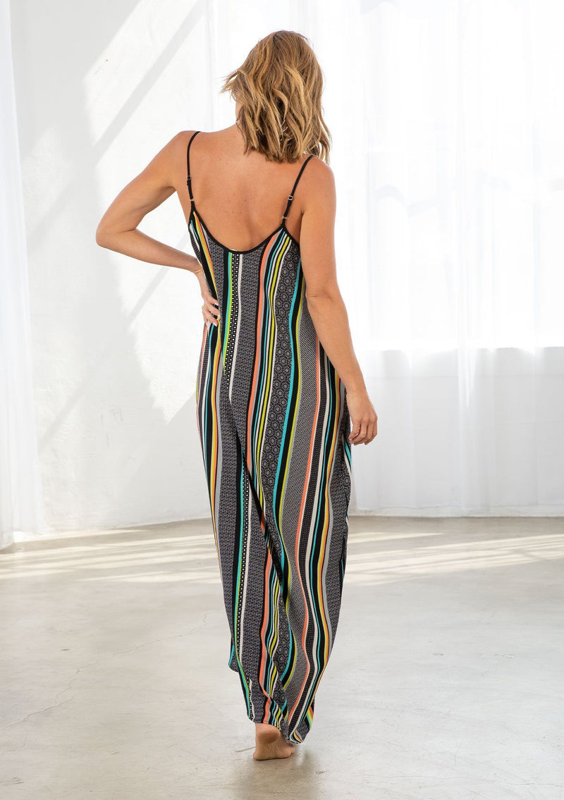 [Color: Black/Multi] A model wearing a multi color striped bohemian maxi dress. With a tie front detail, adjustable spaghetti straps, and side pockets. 