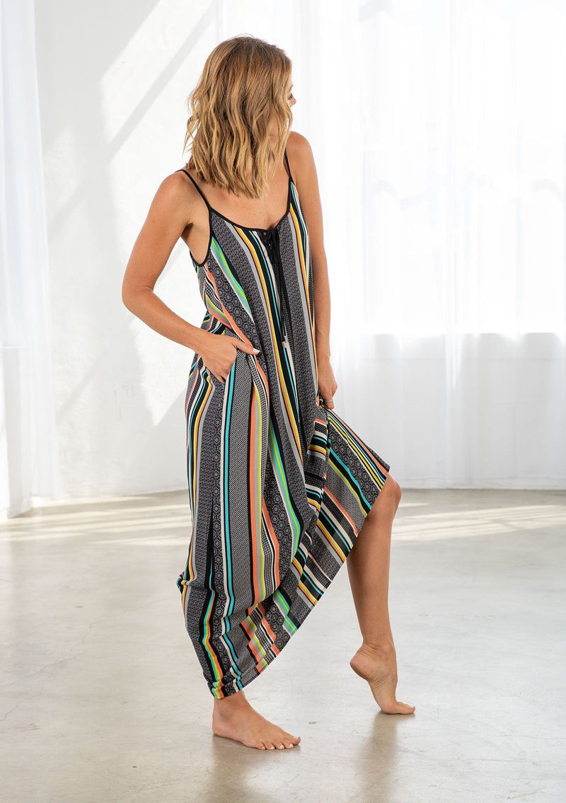 [Color: Black/Multi] A model wearing a multi color striped bohemian maxi dress. With a tie front detail, adjustable spaghetti straps, and side pockets. 