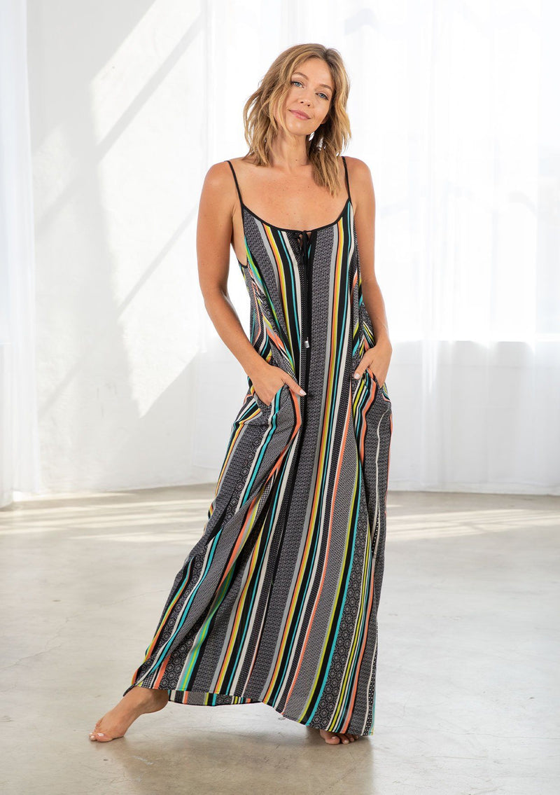 [Color: Black/Multi] A model wearing a multi color striped bohemian maxi dress. With a tie front detail, adjustable spaghetti straps, and side pockets. 