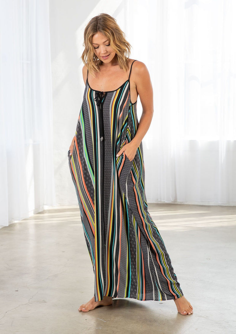 [Color: Black/Multi] A model wearing a multi color striped bohemian maxi dress. With a tie front detail, adjustable spaghetti straps, and side pockets. 