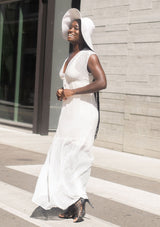 [Color: Off White] A woman wearing a sheer off white chiffon swiss dot maxi dress. With a drawstring empire waist, tiered skirt, v neckline, and lining.