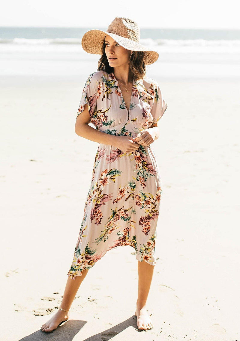 [Color: Silver] A woman on the beach wearing a tropical floral print mid length dress. With short kimono sleeves, a v neckline, an adjustable waist tie, and an open back.