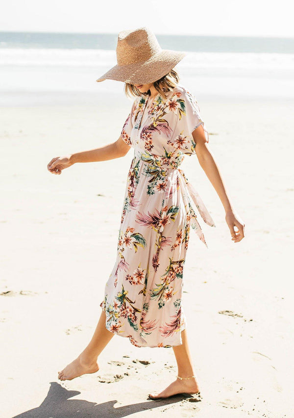 [Color: Silver] A woman on the beach wearing a tropical floral print mid length dress. With short kimono sleeves, a v neckline, an adjustable waist tie, and an open back.