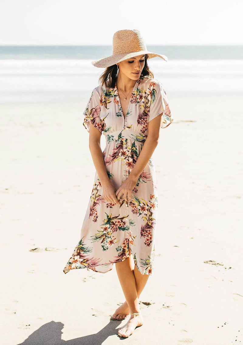 [Color: Silver] A woman on the beach wearing a tropical floral print mid length dress. With short kimono sleeves, a v neckline, an adjustable waist tie, and an open back.