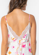 [Color: Ivory/Fuchsia] A model wearing a white maxi slip dress with pink floral print and lace trim. 