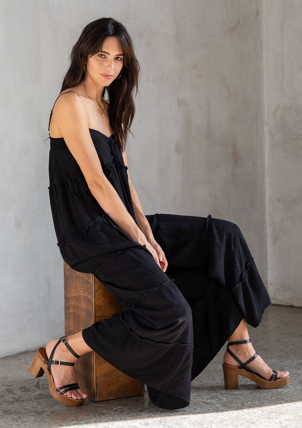 [Color: Black] A model wearing an ultra flowy sleeveless maxi dress, featuring a sweetheart neckline, an empire waist, and ruffled details. Perfect beach dress. 