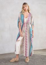 [Color: Mauve Multi] A model wearing a multi colored paisley print kimono. Featuring a tassel tie closure.