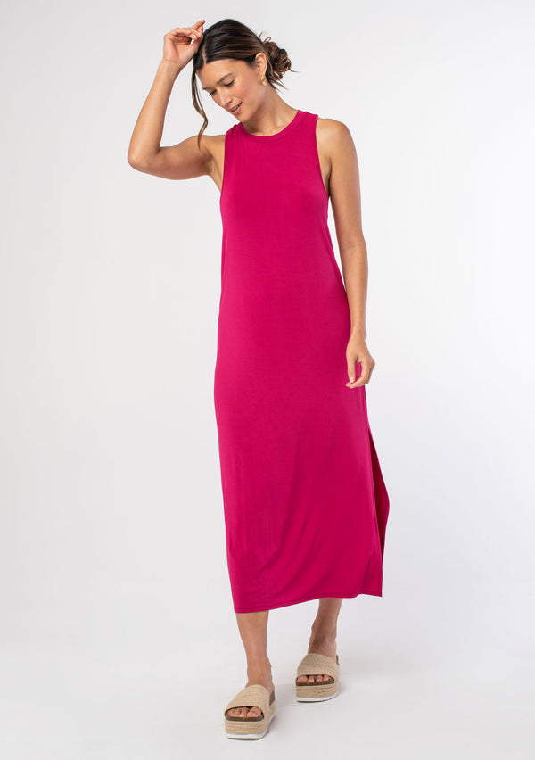 [Color: Mulberry] A model wearing a soft and stretchy sleeveless pink maxi dress. With a round crew neckline, a sexy side slit, a racer back with a knot detail, and a relaxed fit.