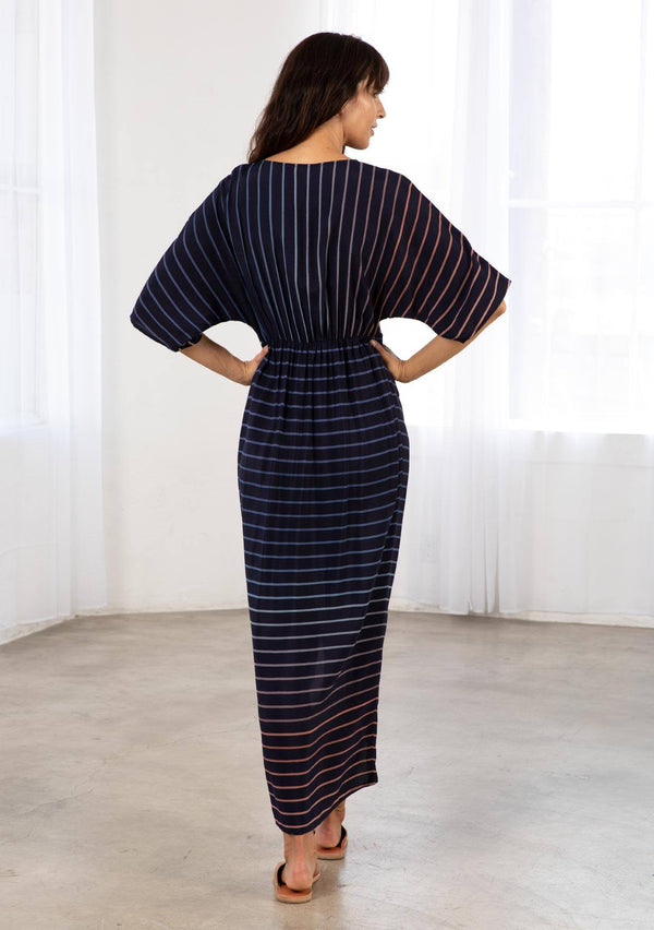 [Color: Navy/Blue] A bohemian maxi dress in a gradient stripe print. With half length kimono sleeves, a deep v neckline, a front slit, and a front knot detail at the waist. 