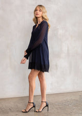 [Color: Navy/Black] A model wearing a sophisticated navy and black sheer chiffon mini dress, perfect for holiday parties. With a pretty lace trim hemline and wrist cuffs. 