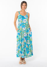 [Color: Green/Aqua] A model wearing a flowy bohemian maxi tank dress in a bright green and blue retro floral print. 